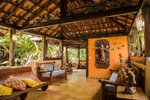 a living room with benches and chairs in a house at Pousada Bemvirá in Arraial d'Ajuda
