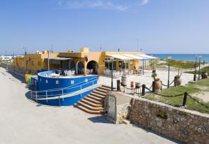 ein Gebäude mit einem blauen Boot am Meer in der Unterkunft Eurocamping in Oliva