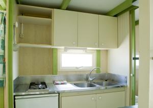 a small kitchen with a sink and a stove at Eurocamping in Oliva