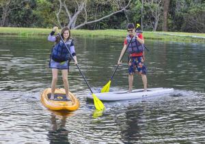 a man and a woman paddle a paddle boat through the water at Brotas Eco Hotel Fazenda in Brotas