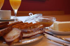 a plate of bread and cheese and a glass of orange juice at Posada Rural La Sosiega in Argüeso