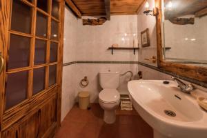 a bathroom with a white toilet and a sink at Casa Elvira in Tajace de Abajo