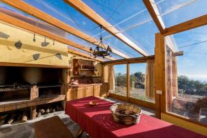 cocina con mesa roja en una habitación con ventanas en Casa Elvira, en Tajace de Abajo