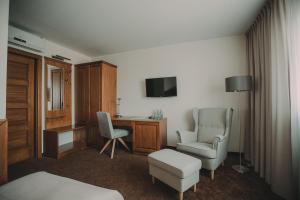Habitación de hotel con cama, escritorio y sillas en Hotel Restaurant Boss, en Miłosław