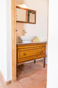 La salle de bains est pourvue d'un lavabo sur une commode en bois. dans l'établissement Herdade da Maxuqueira, à Gavião