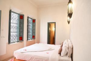 1 dormitorio con cama y espejo en Riad Dar Aicha en Exclusivité, en Marrakech