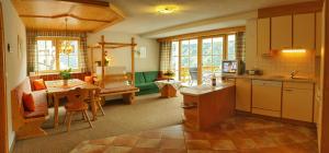 a kitchen and living room with a table and a dining room at Landhaus Raich in Jerzens