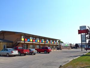 un edificio con coches estacionados en un estacionamiento en Westgate Inn, en Portage La Prairie