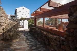 Casa de piedra con pared de piedra y ventanas en Casa Abuela María, en Isora