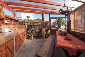 a kitchen with a bench and a stone wall at Casa Abuela María in Isora