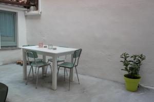 a white table with four chairs and a plant at My Eco Rooms Olbia in Olbia