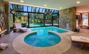 una gran piscina en una casa con una gran ventana en Hostería Huenú en Villa La Angostura