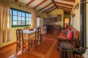 cocina y sala de estar con mesa y nevera en Casa Tia Estebana, en Isora