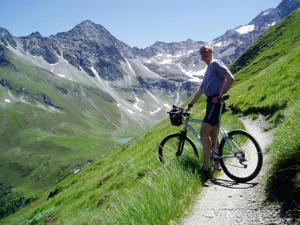 a man standing next to a bike on a mountain at Ferienhaus Posthüttl in Virgen