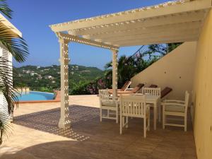 a patio with a table and chairs under a pergola at South Sea House in Cap Estate