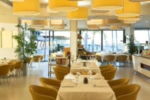 a restaurant with tables and chairs and large ceilings at Alimounda Mare Hotel in Karpathos