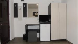 a room with a desk with a television and a cabinet at Guest House Dar in Tryavna