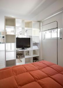 ein Schlafzimmer mit einem Bett und einem Flachbildfernseher in der Unterkunft Color Botánico in Buenos Aires