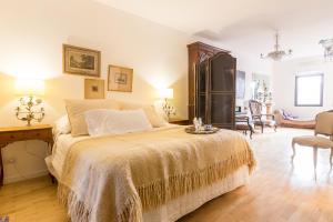 a bedroom with a large bed and a chair at Virreinato Hotel Boutique in Córdoba