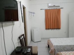 a small room with a television and a table and a table sidx sidx at Pousada Casa da Lucinha in Fortaleza