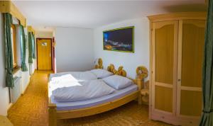 a bedroom with a bed with white sheets at Panorama Restaurant Sterzingerhaus 1.930m in Vipiteno
