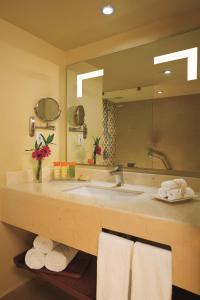 ein Badezimmer mit einem großen Waschbecken und einem großen Spiegel in der Unterkunft Sunscape Puerto Vallarta Resort in Puerto Vallarta