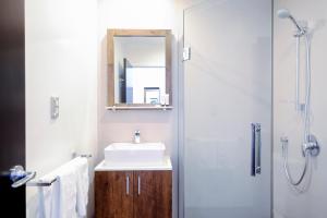 a bathroom with a sink and a shower with a mirror at No. 9 Hotel in Auckland