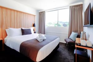 a hotel room with a bed with a teddy bear on it at No. 9 Hotel in Auckland