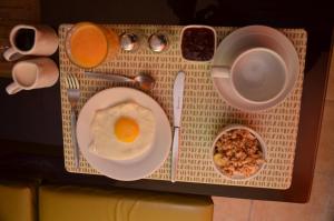a breakfast tray with an egg and a cup of coffee at Hostal Mallqui in Cusco