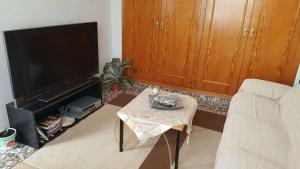 uma sala de estar com uma televisão e uma mesa de centro em Casa de los amigos em Busot