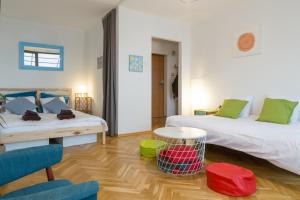 - un salon avec deux lits, une table et des chaises dans l'établissement WSTApartments Sunset View Krucza 46, à Varsovie 13 autres photos