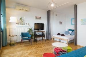 un salon avec un lit et une télévision dans l'établissement WSTApartments Sunset View Krucza 46, à Varsovie