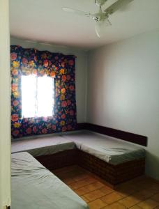 Habitación con 2 camas frente a una ventana en Condomínio Village do Itanhém, en Alcobaça