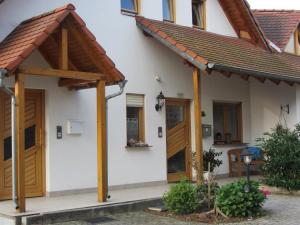 uma casa com portas de madeira e um telhado em Fewo No. 17- Langgons / Oberkleen em Langgöns