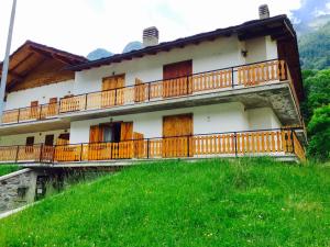 a building with a balcony on top of a hill at Casa del Lago in Valtournenche