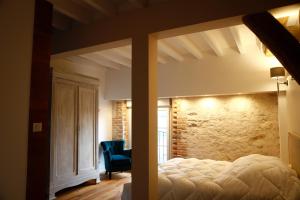 a bedroom with a bed and a stone wall at Gîte de la Crayère in Gionges