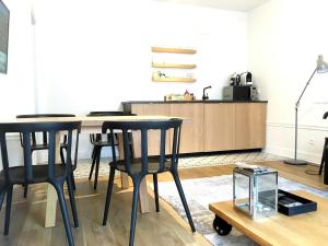 a kitchen with two black chairs and a table at Apartament August in Gdynia