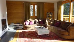 a living room with couches and a coffee table at Chalet Les Jumelles in Les Allues