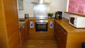 a kitchen with wooden cabinets and a microwave at Chalet Les Jumelles in Les Allues