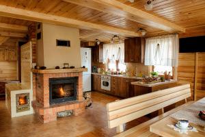 ein Wohnzimmer mit Kamin und eine Küche in der Unterkunft Aleksandrówka - Domek Anastazja in Trześcianka