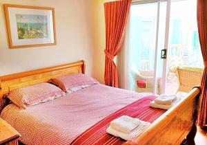 a bedroom with a bed with two towels on it at Coconut Cottage - A Romantic Cosy Cottage by the Sea! - You'll love this adorable Seaside Gem Just a few steps from the Beach! Perfect for Couples & Family's in Sutton on Sea