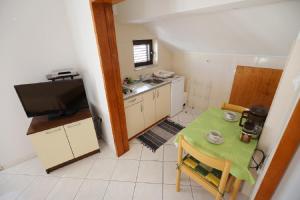 cocina pequeña con mesa pequeña y TV en Studio Apartments Pavin, en Zadar