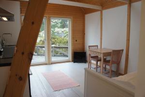 a kitchen and dining room with a table and a window at Idöborgs Stuguthyrning in Nämdö