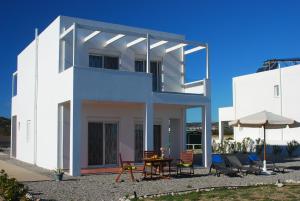 a white house with a table and chairs at Villa Mangano in Afantou