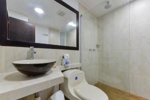 a bathroom with a sink and a toilet and a mirror at Hotel Portofino in San Andrés