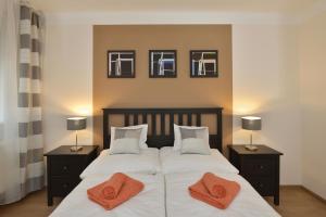 1 dormitorio con 2 camas con almohadas de color naranja en Deak Apartment, en Budapest