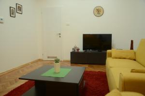 a living room with a couch and a table and a tv at Sarajevo City Center in Sarajevo