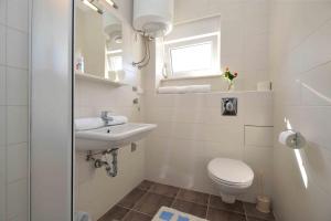 a white bathroom with a toilet and a sink at Apartments Bilanovic in Tisno +99 photos