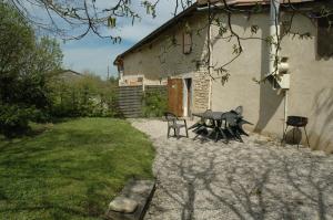 a table and chairs in front of a building at Le Bellaton in Ambronay