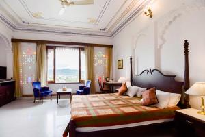 a bedroom with a bed and a table and chairs at Hotel Raj Kuber in Udaipur